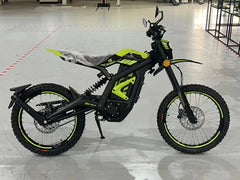 Black electric bike with green accents on a gray floor