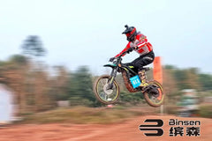 Biker in mid-air on a dirt bike with Binsen logo in the background