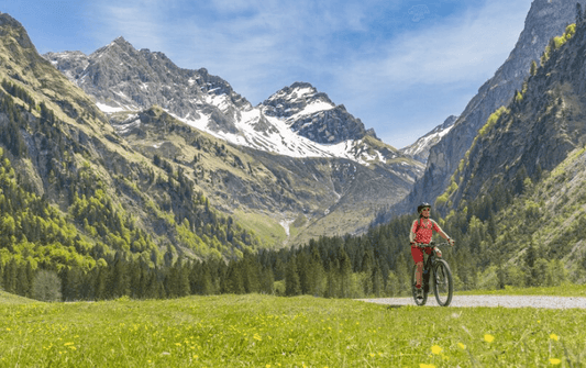 Electric road bike ridden on a mountain trail with scenic alpine landscape and blue sky